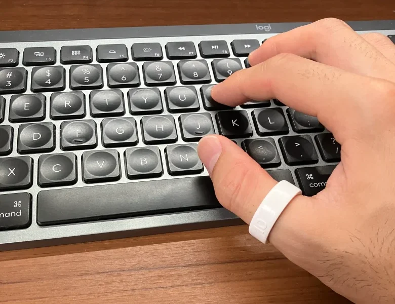 Oura Ring 4サイジングキットのサイズ10(USモデル)を親指に装着しキーボードを操作している様子