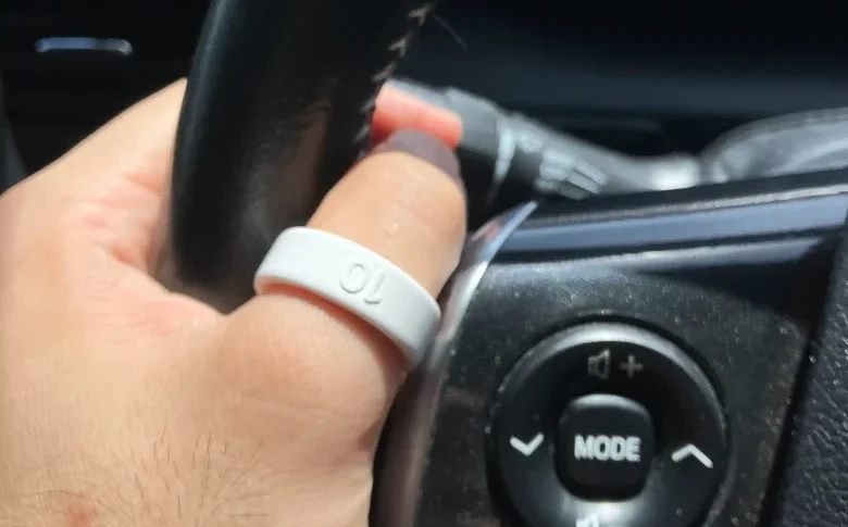 Oura Ring 4サイジングキットのサイズ10(USモデル)を左手の親指に装着し自動車のハンドルを持っている様子
