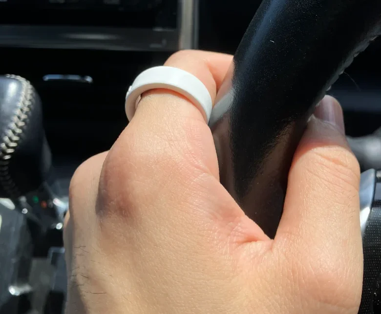 Oura Ring 4サイジングキットのサイズ9(USモデル)を左手の人差し指に装着し自動車のハンドルを持っている様子