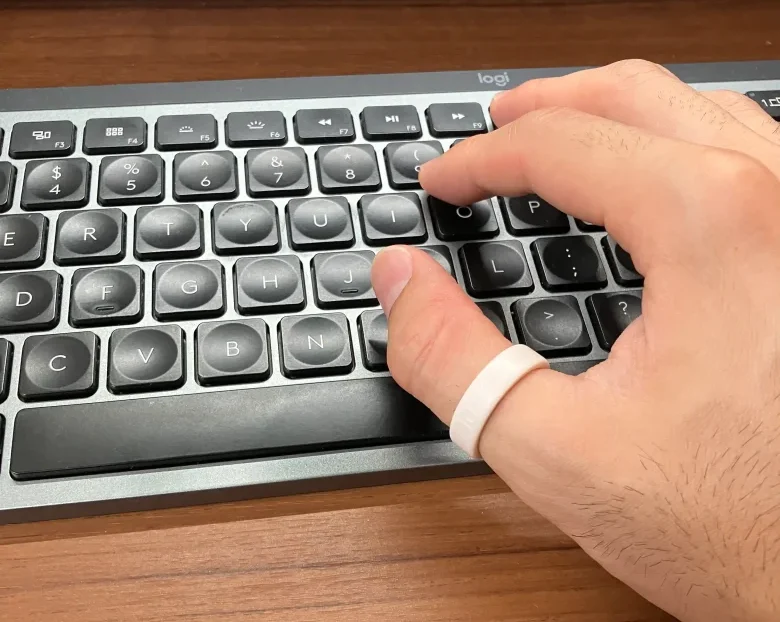 Oura Ring 5サイジングキットのサイズ10(USモデル)を親指に装着しキーボードを操作している様子