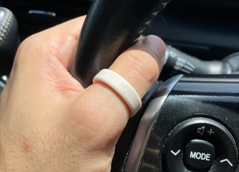 Oura Ring 5サイジングキットのサイズ10(USモデル)を左手の親指に装着し自動車のハンドルを持っている様子