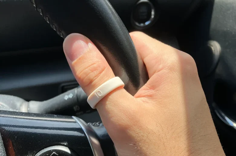 Oura Ring 5サイジングキットのサイズ10(USモデル)を右手の親指に装着し自動車のハンドルを持っている様子