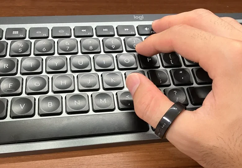 RinnConnサイジングキットのサイズ10(USモデル)を親指に装着しキーボードを操作している様子