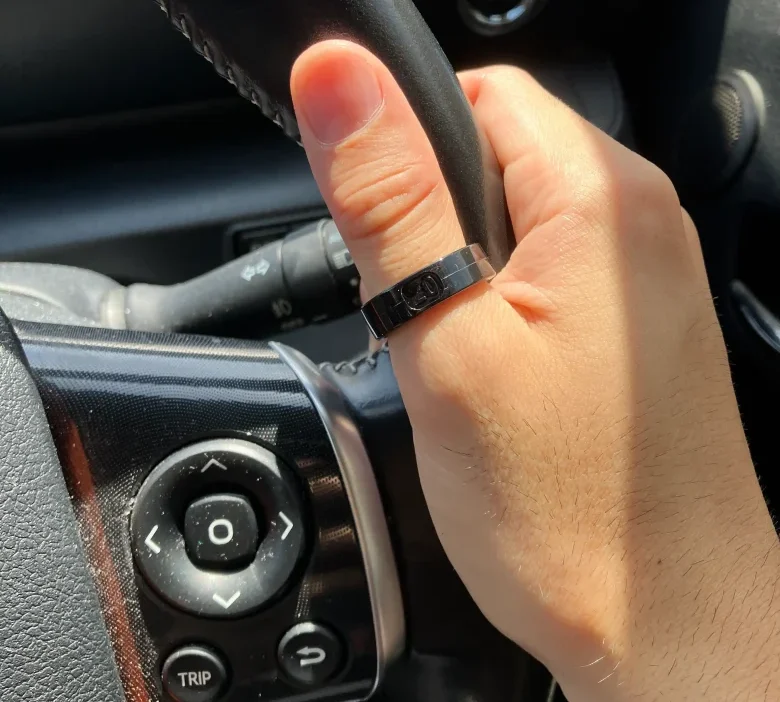 SOXAI RING 2サイジングキットのサイズ20を右手の親指に装着し自動車のハンドルを持っている様子