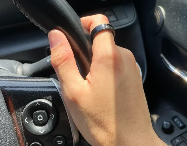 SOXAI RING 2サイジングキットのサイズ20を右手の人差し指に装着し自動車のハンドルを持っている様子